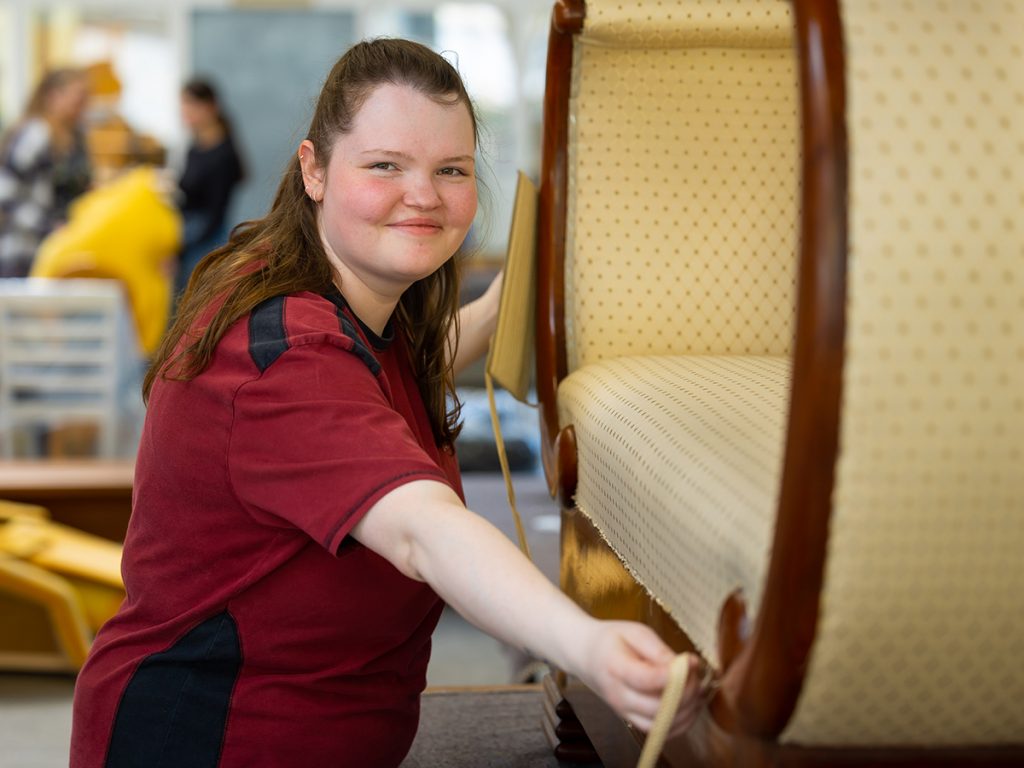 Polsterin beim Ausmessen eines Sofas